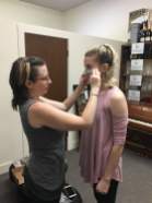 Kendra Johnson, Mask Artisan, fits a fairy mask to Colleen Scallen, Attendant and Mulberry.